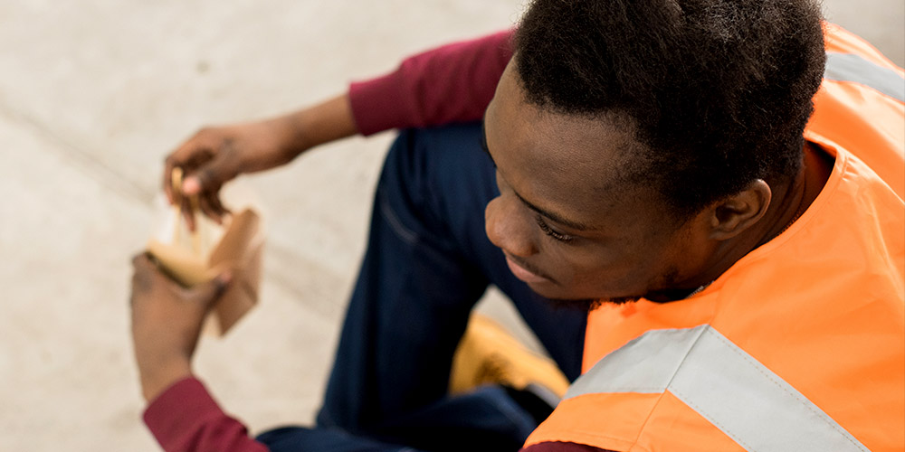 Innovative Learning Solutions Website Image African Truck Training Man Sitting Down Wearing Orange Vest